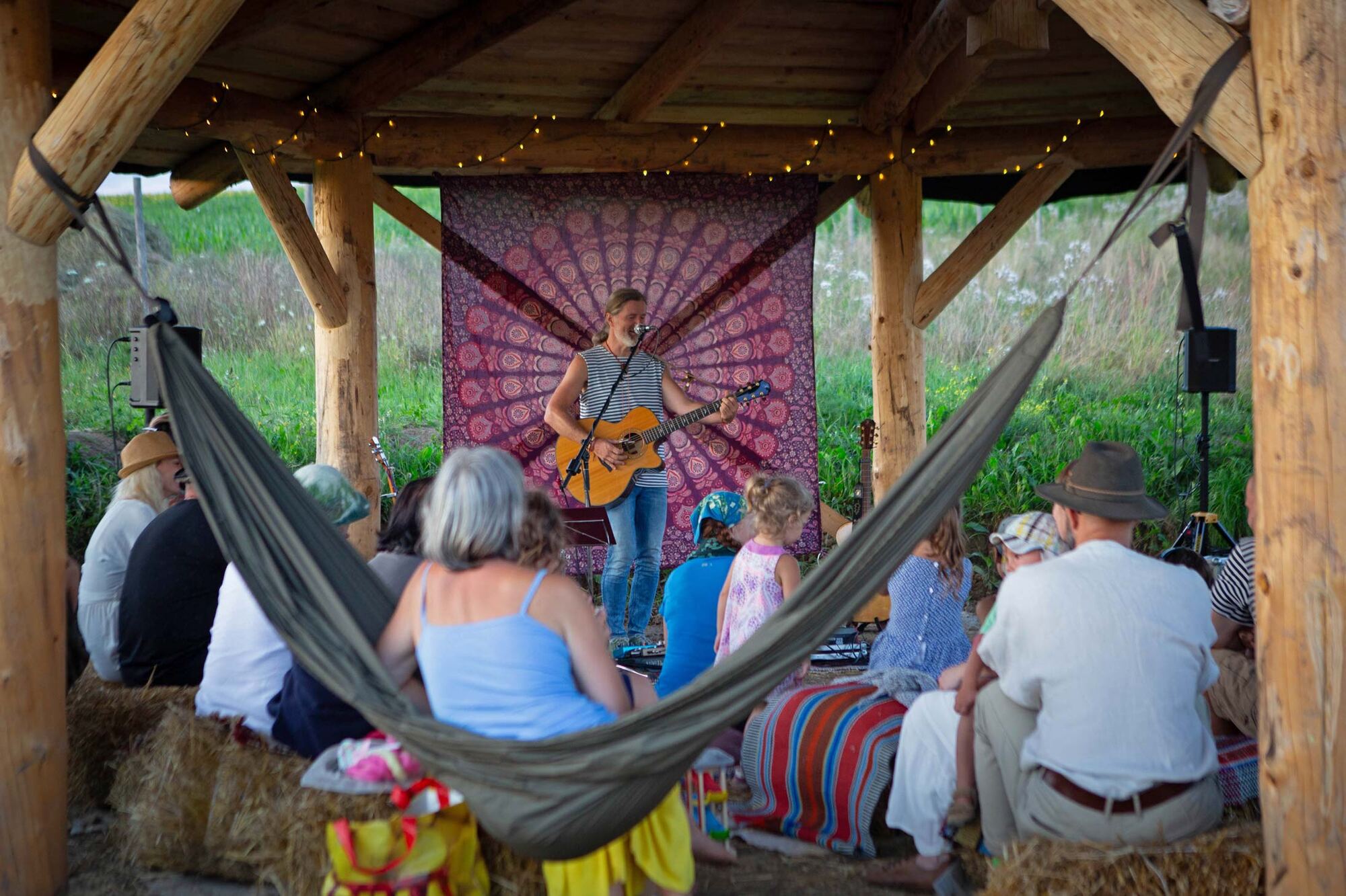 Koncert pod drevenou strechou altánku, diváci v hamakoch