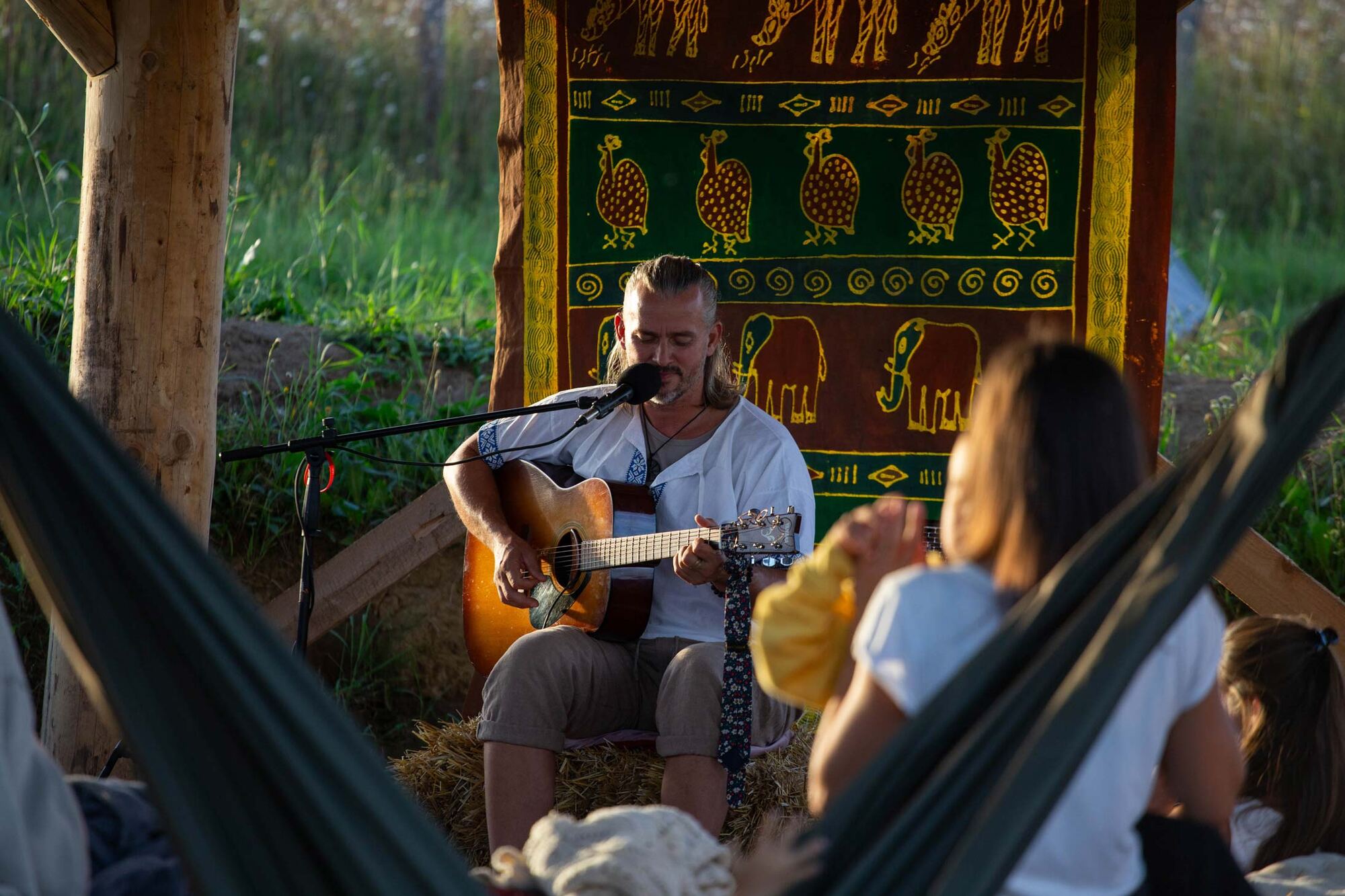 Hudobník s gitarou na večernom koncerte pod altánkom